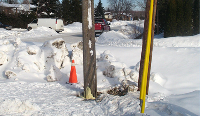 Telephone pole with construction cone in snow